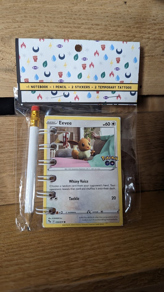 Pokémon card notebooks are packaged with a pencil, two random stickers, and two random temporary tattoos.